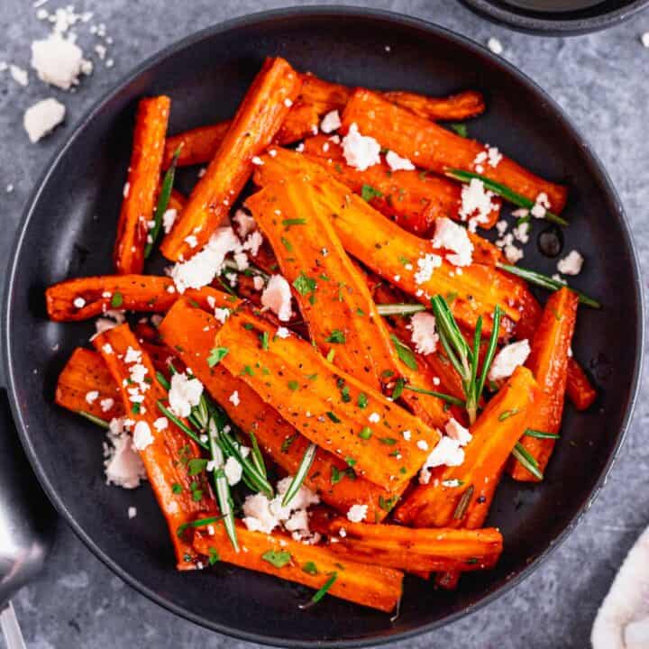 Honey Glazed Carrots In Air Fryer With Feta and Rosemary in a black bowl