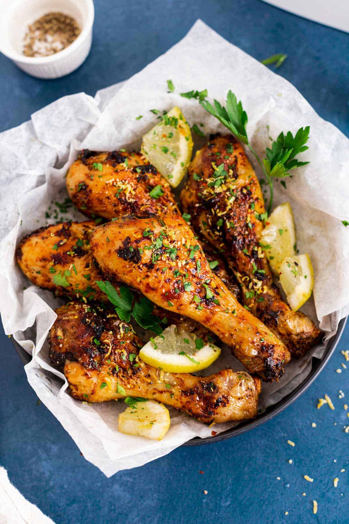 cooked lemon garlic chicken legs in air fryer basket