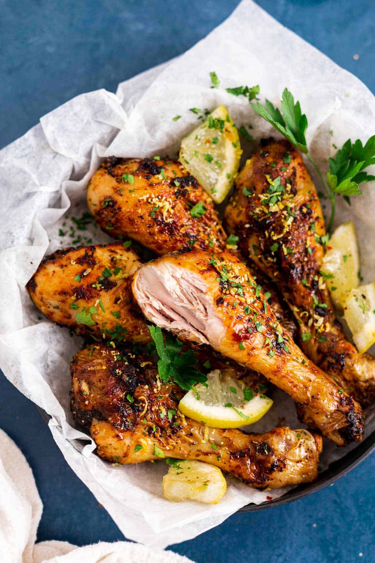 cooked lemon garlic chicken legs in air fryer basket