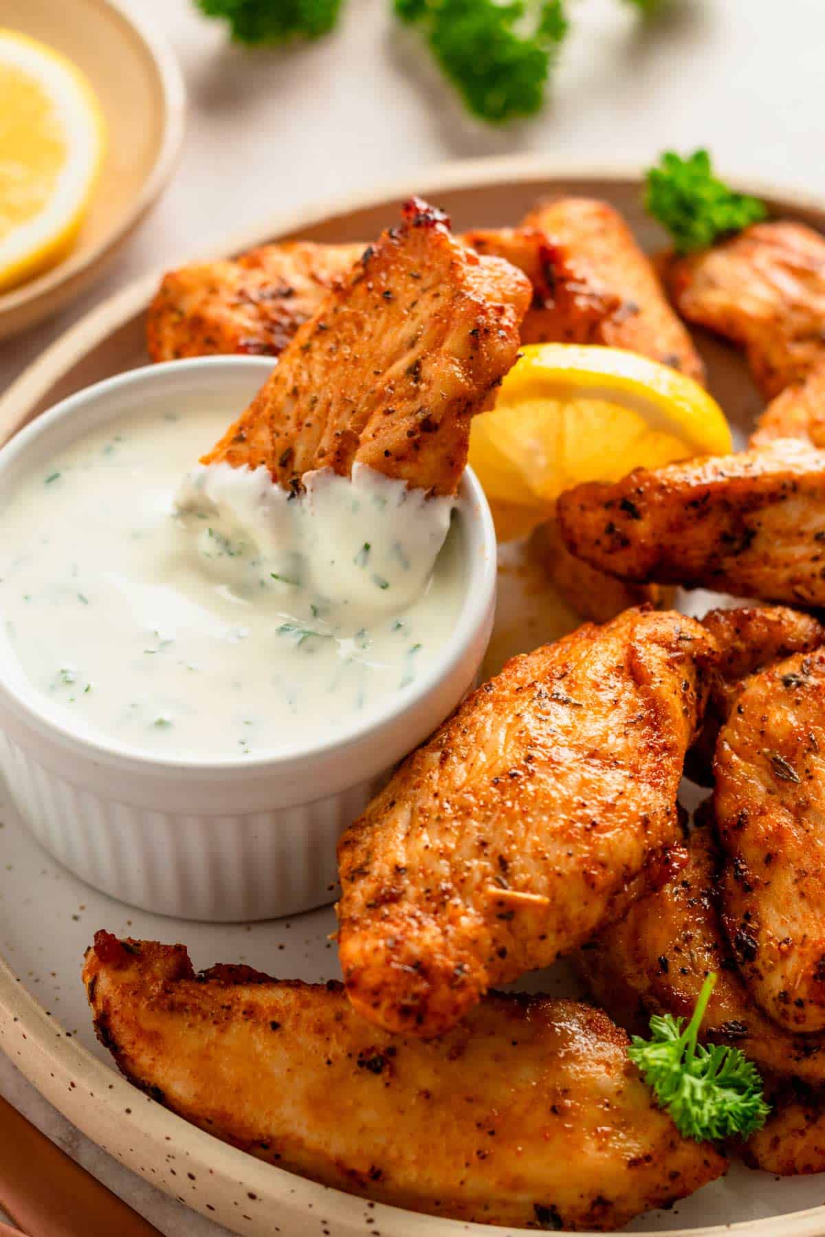 air fryer chicken tenders served with white dipping sauce.