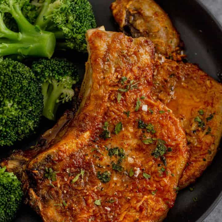 cooked bone in pork chops in a bowl with broccoli