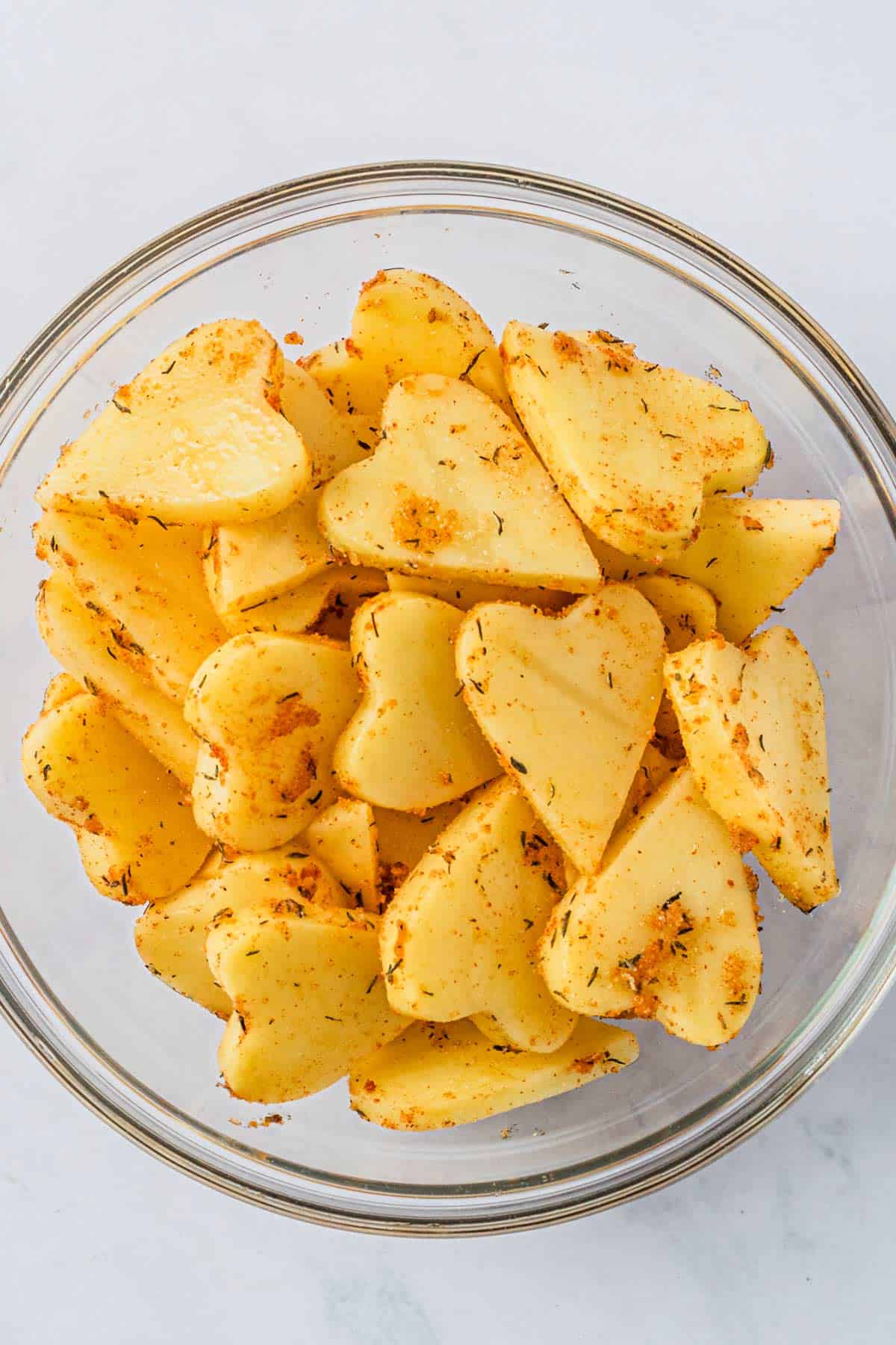 sliced potatoes in a bowl with seasonings