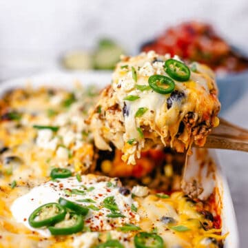 Beef Enchilada Casserole closeup on a wooden spoon