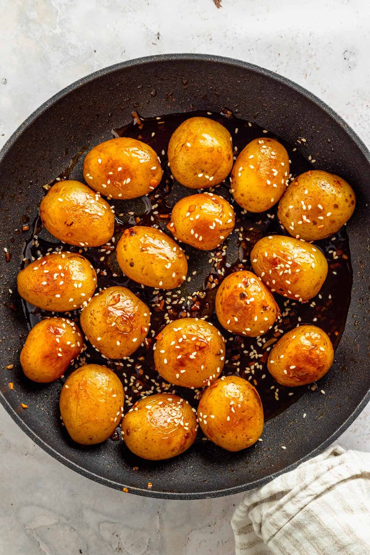 baby potatoes with dark sauce in skillet.