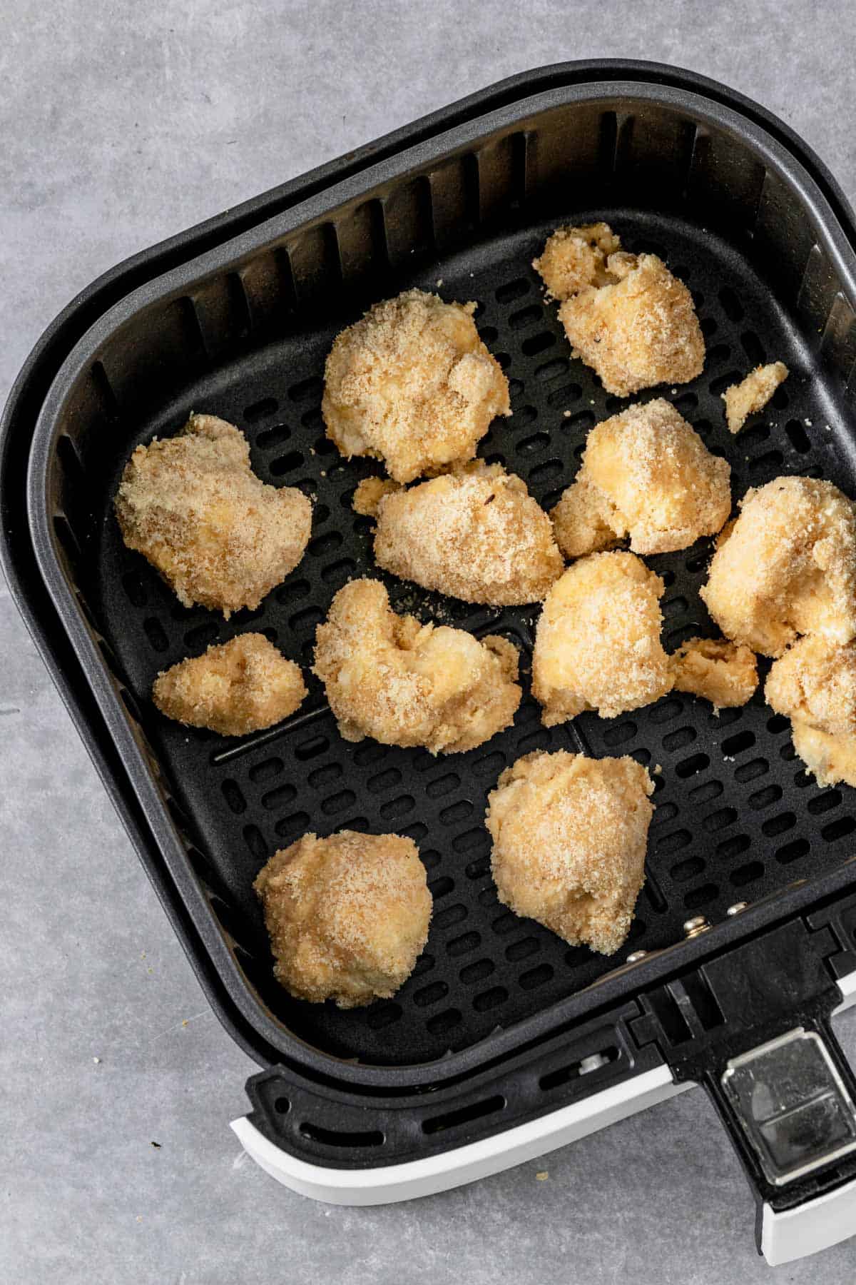 buffalo cauliflower in air fryer basket before baking