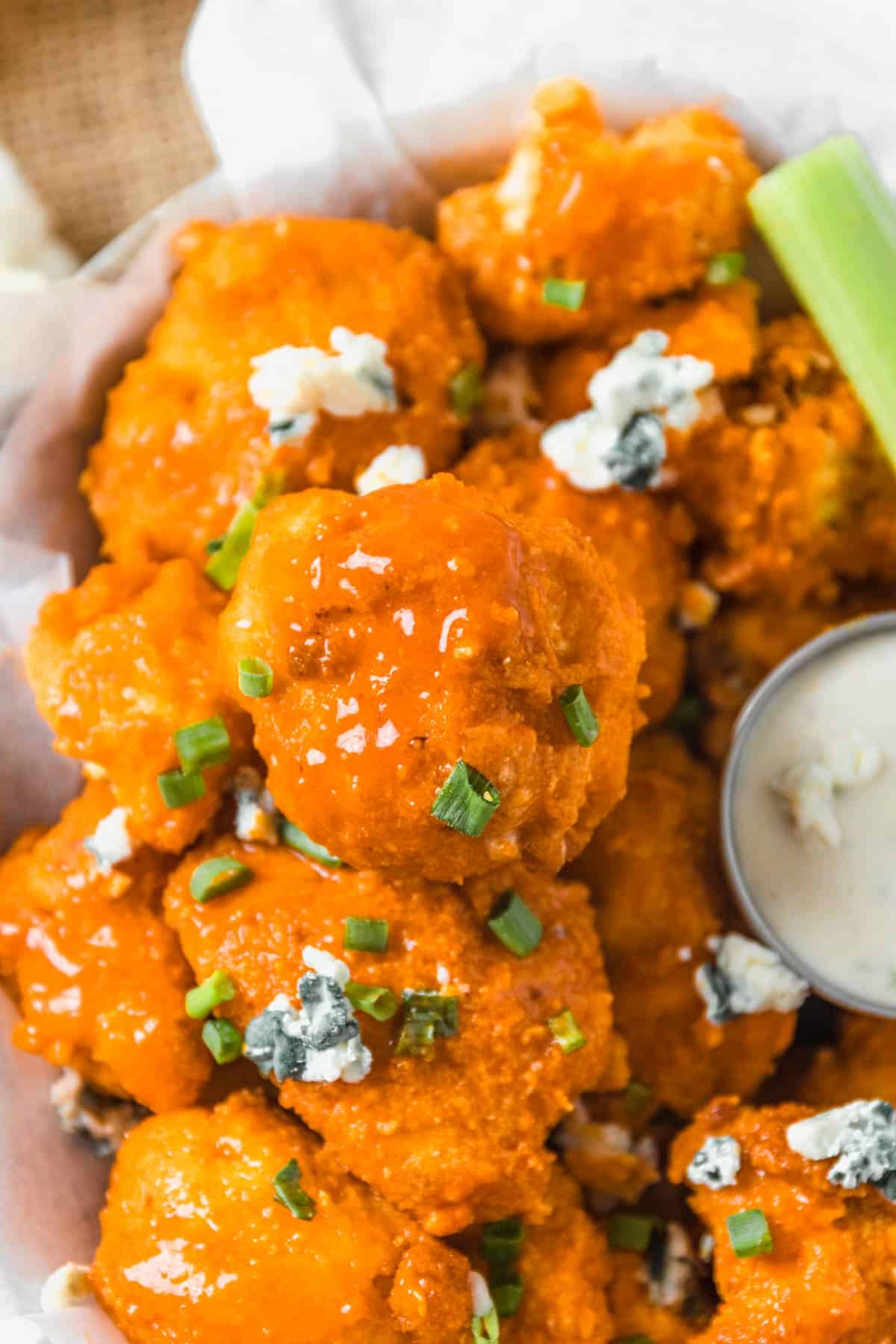 Buffalo Cauliflower Bites with blue cheese crumbles and sauce