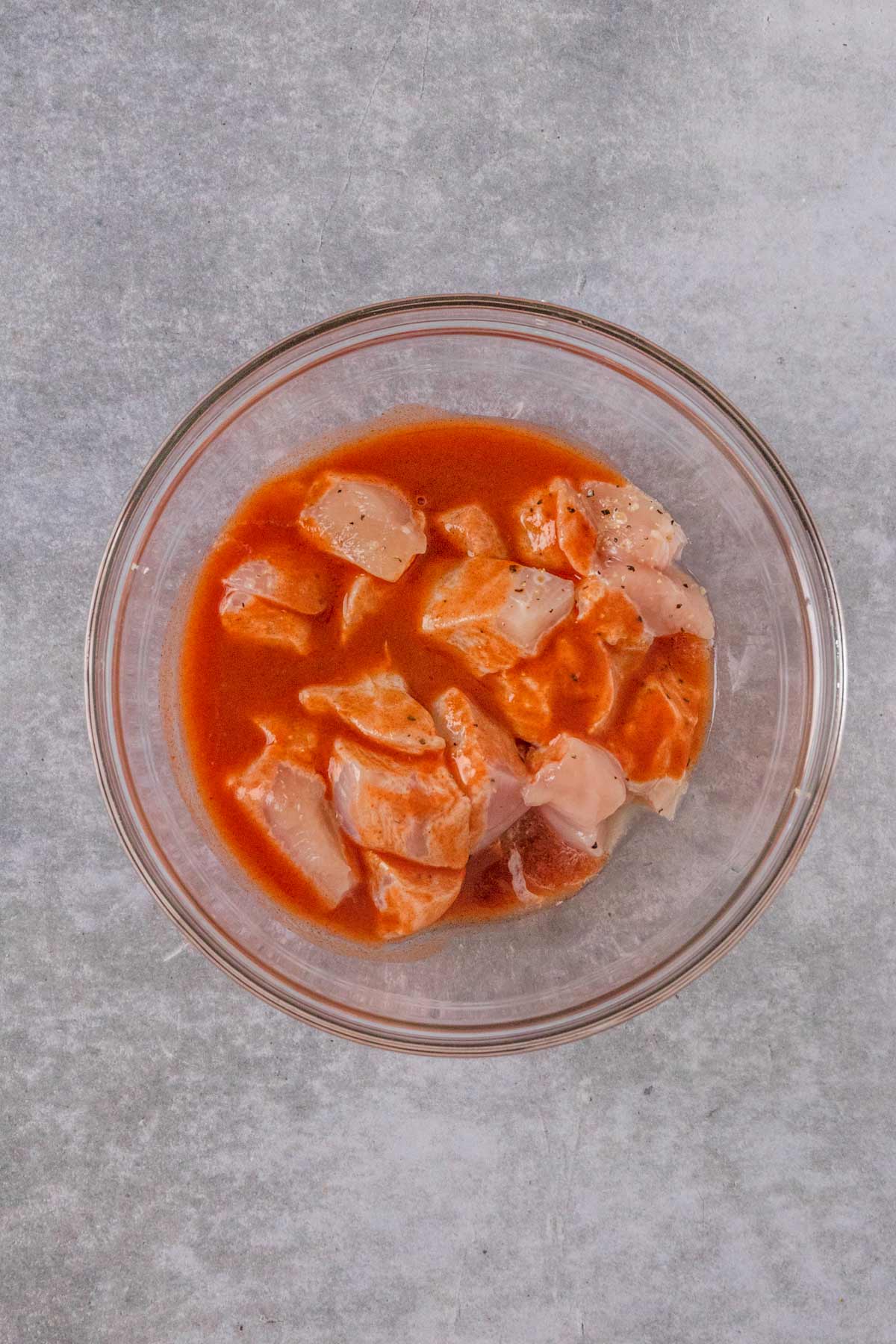 chicken pieces marinating in hot sauce