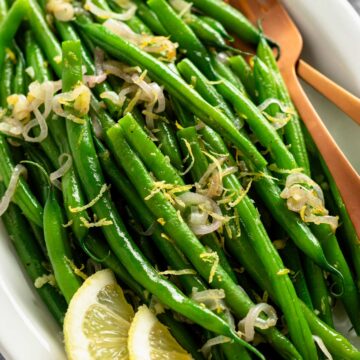 ready to be served garnished green beans with lemon slices.