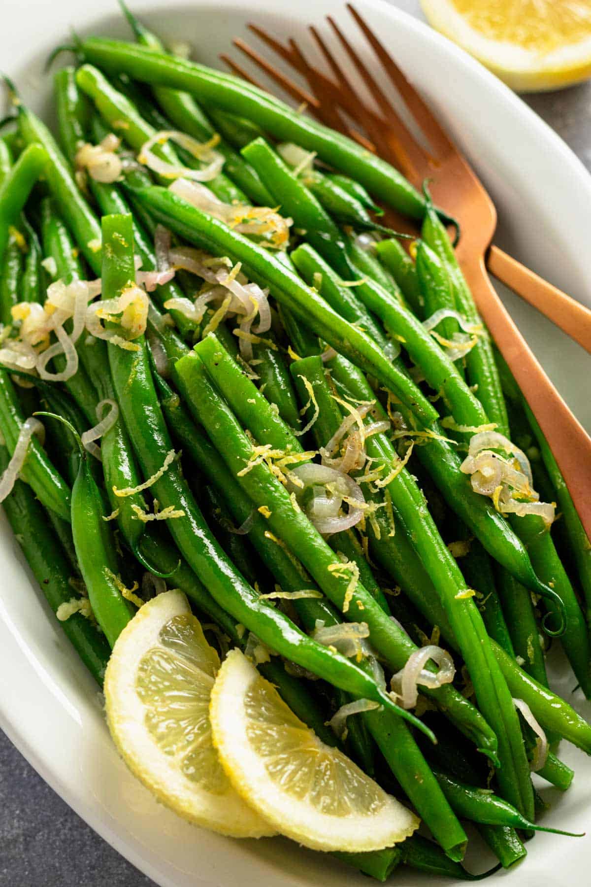 ready to be served garnished green beans with lemon slices.