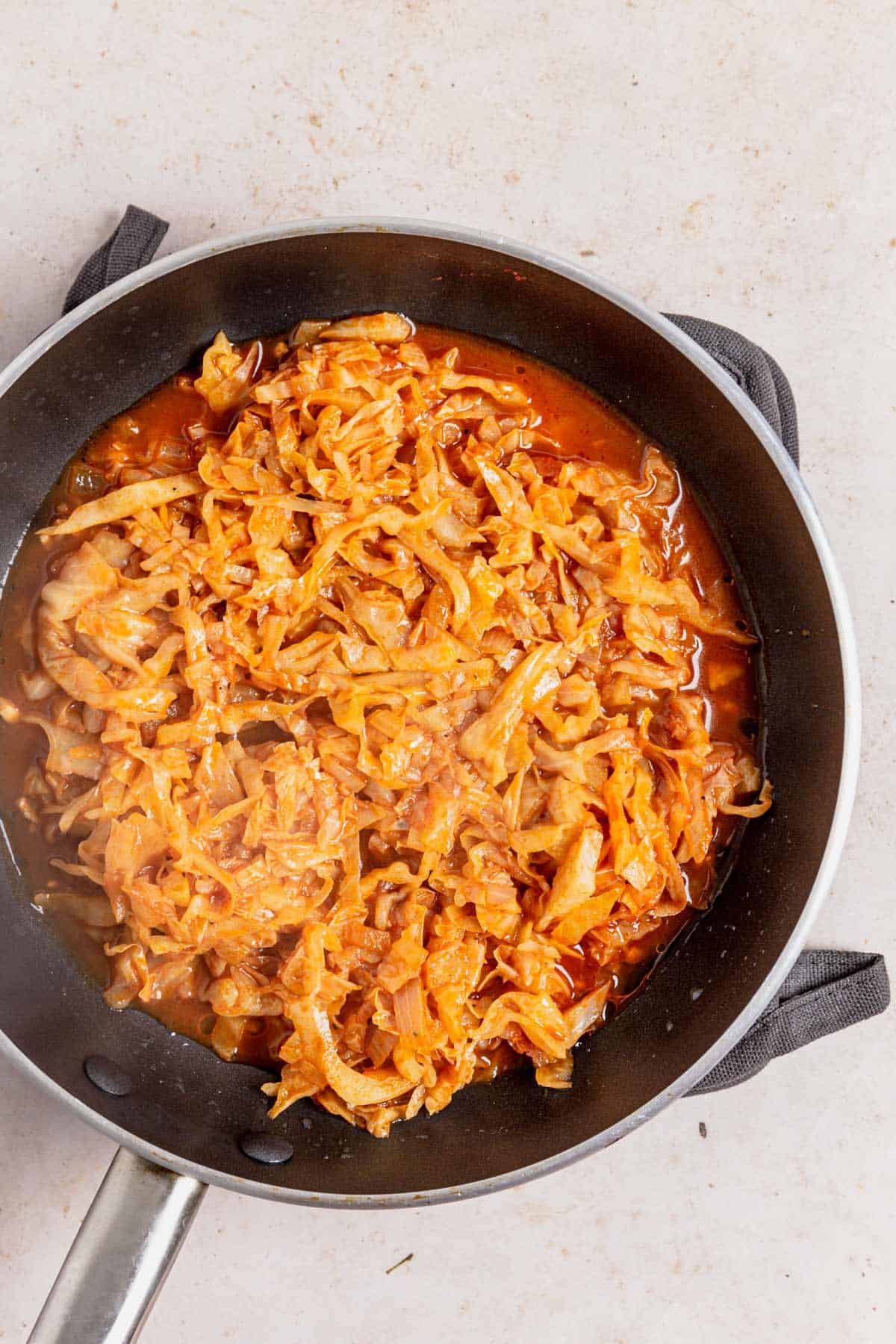 cabbage cooking in tomato paste, seasoning and chicken broth