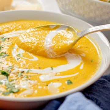 carrot ginger turmeric soup with cream in a bowl