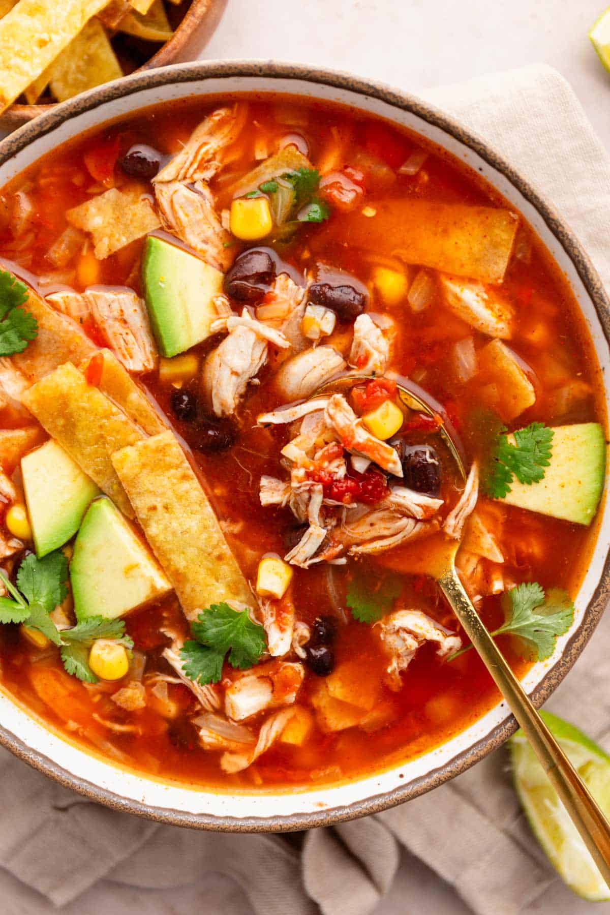 chicken tortilla soup with toppings in a bowl.