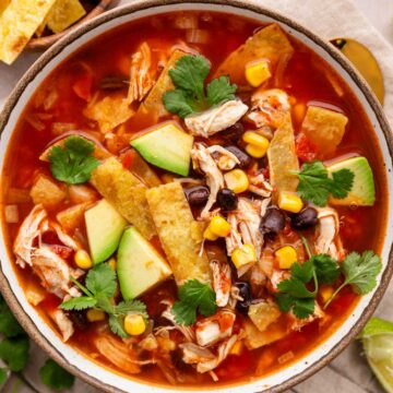 chicken tortilla soup with toppings in a bowl.