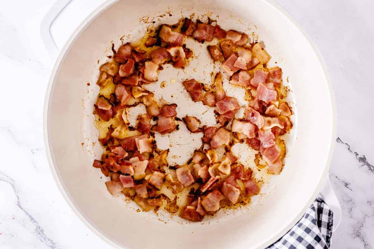 Saute bacon in a white pot