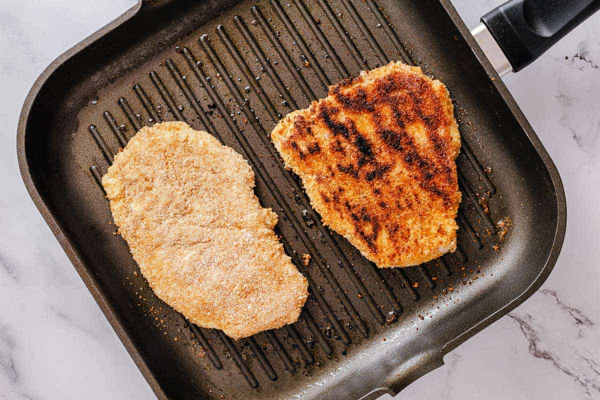 breaded chicken fried on a grill pan