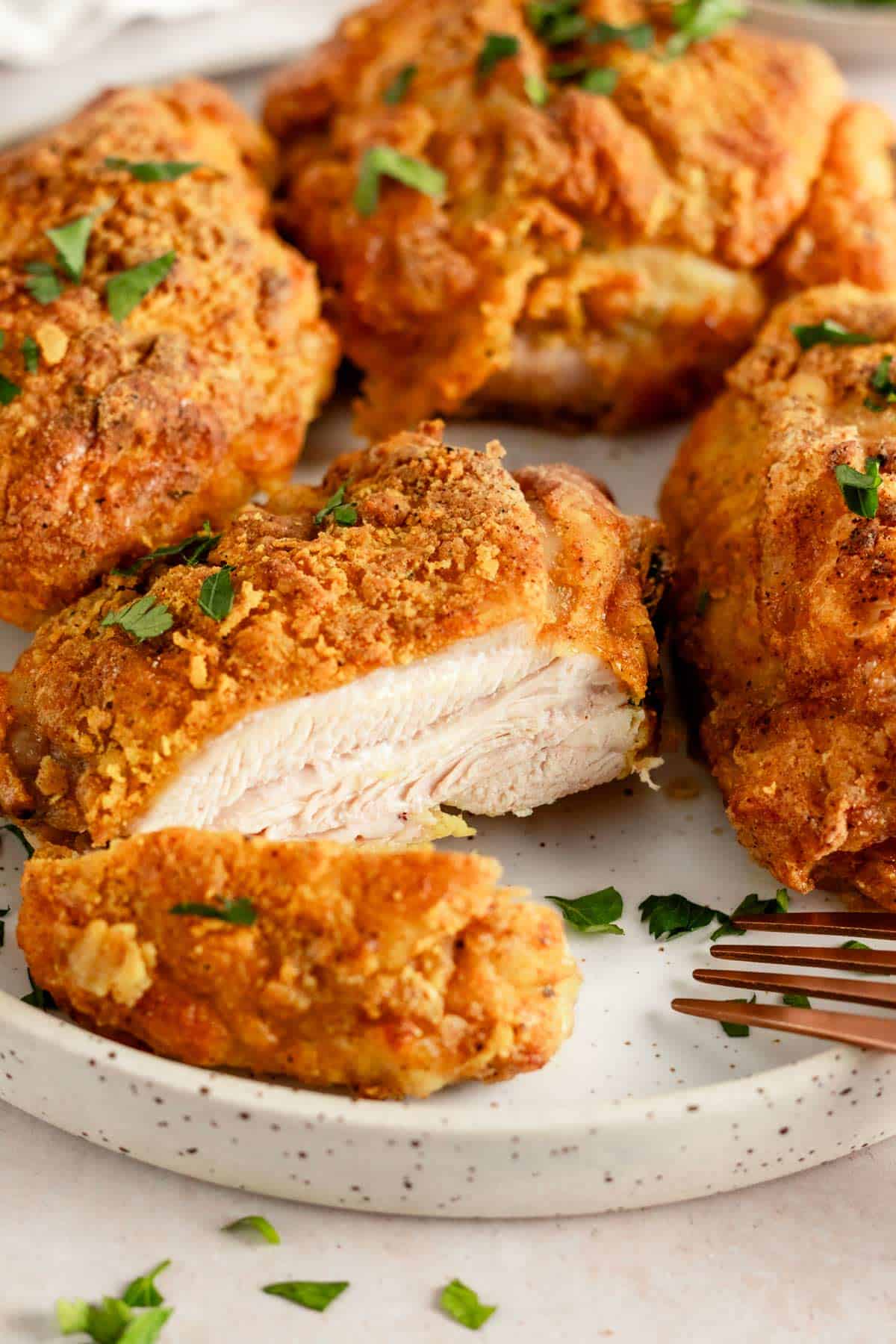 crispy skin sliced chicken thighs on a plate.