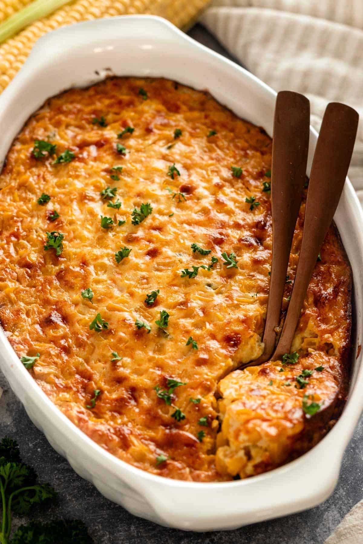 serving a hot piece of corn casserole from baking dish.