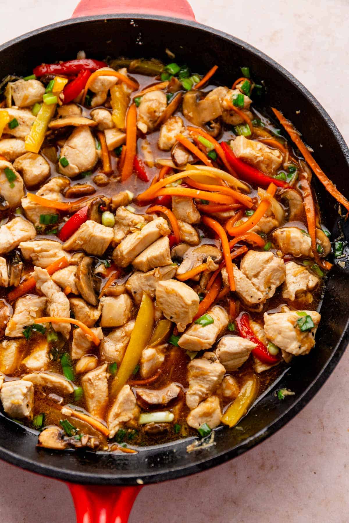 lo mein style noodles with veggies and chicken in skillet.