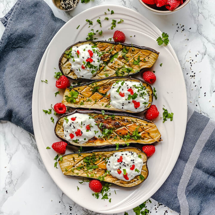 Oven-Roasted Eggplant boats loaded with yogurt and goat cheese dressing and a bit of raspberry together create a delicious and delicate flavor that almost asking to be eaten immediately.