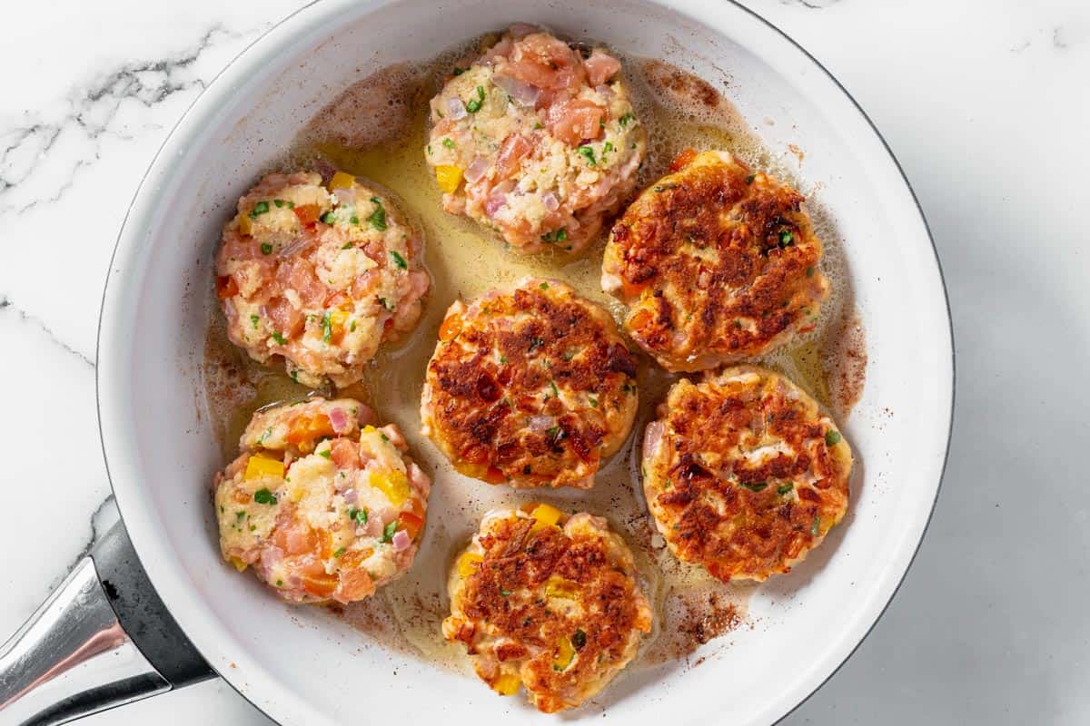 salmon patties frying in a skillet