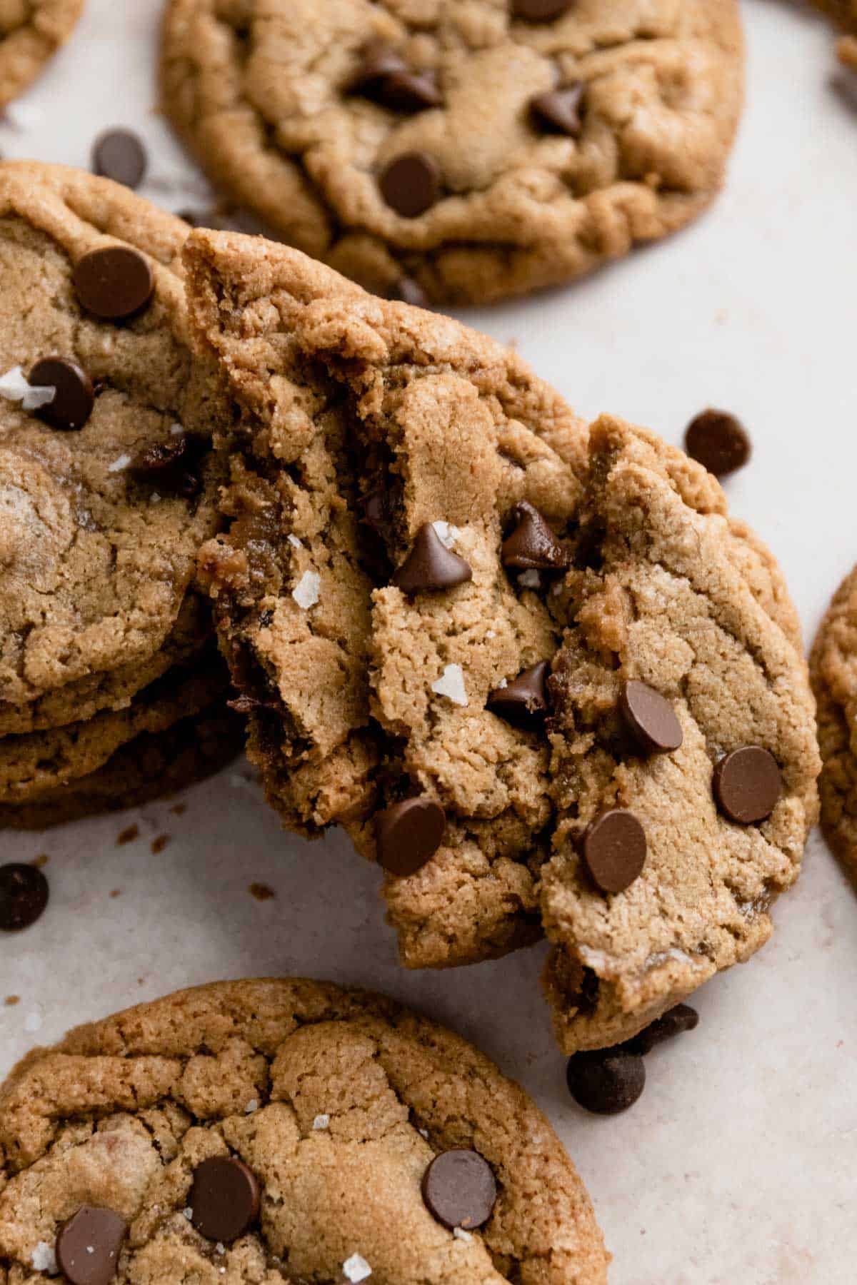 a stack of cut in half gluten free chocolate chip cookies with sea salt flakes