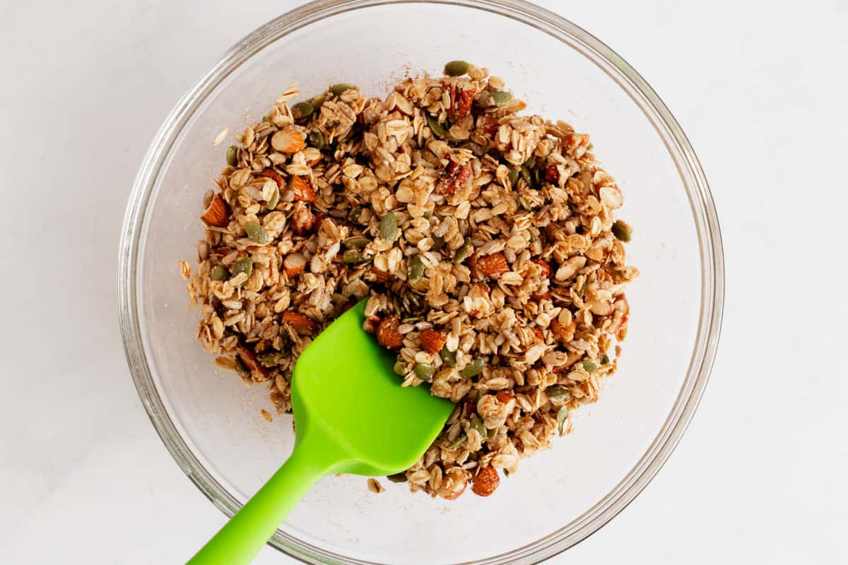 oats with honey, maple syrup and nuts and seeds in a bowl