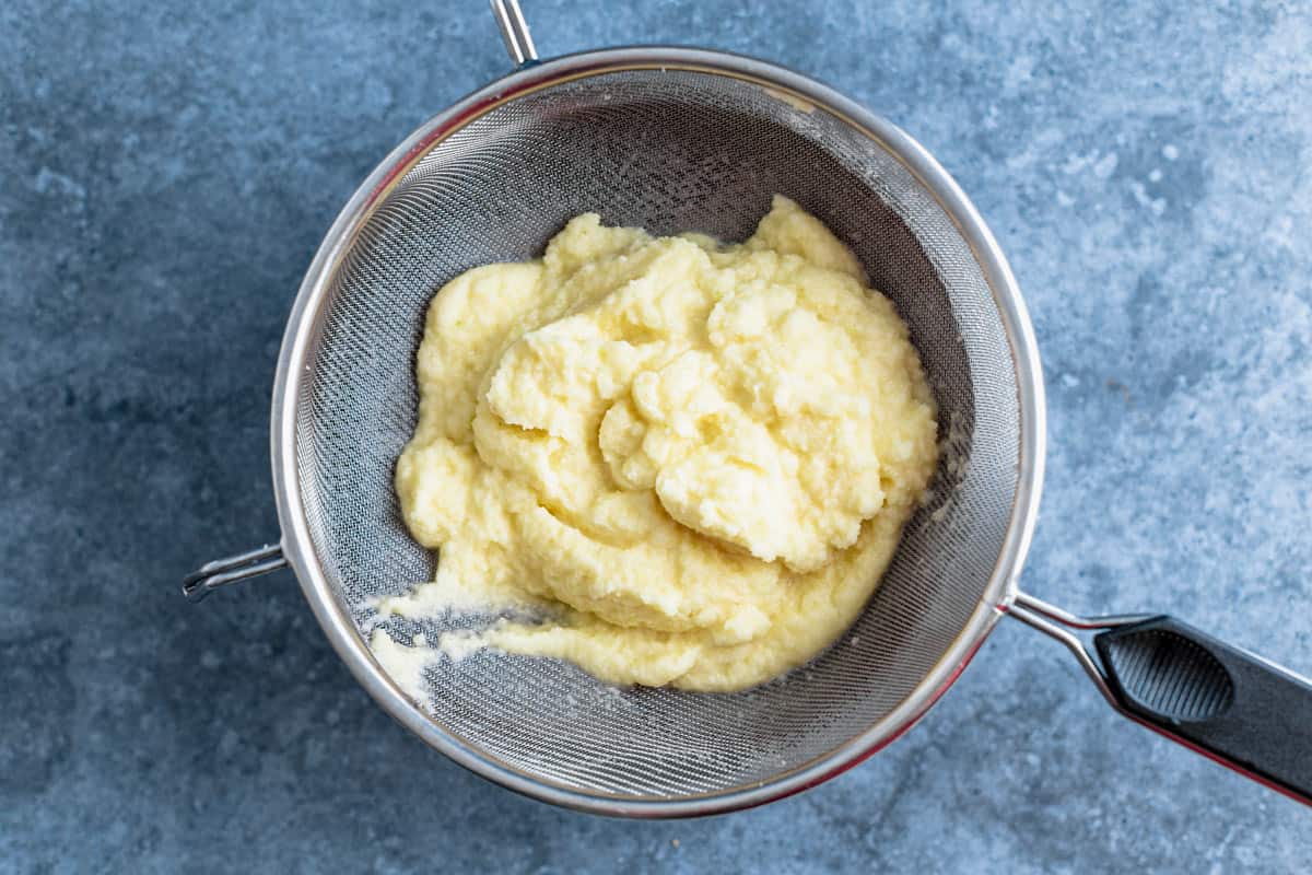 potato pancakes batter in a mesh strainer