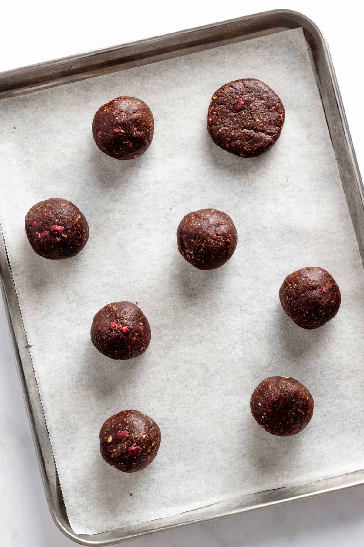 rolled cookie dough balls on baking sheet.