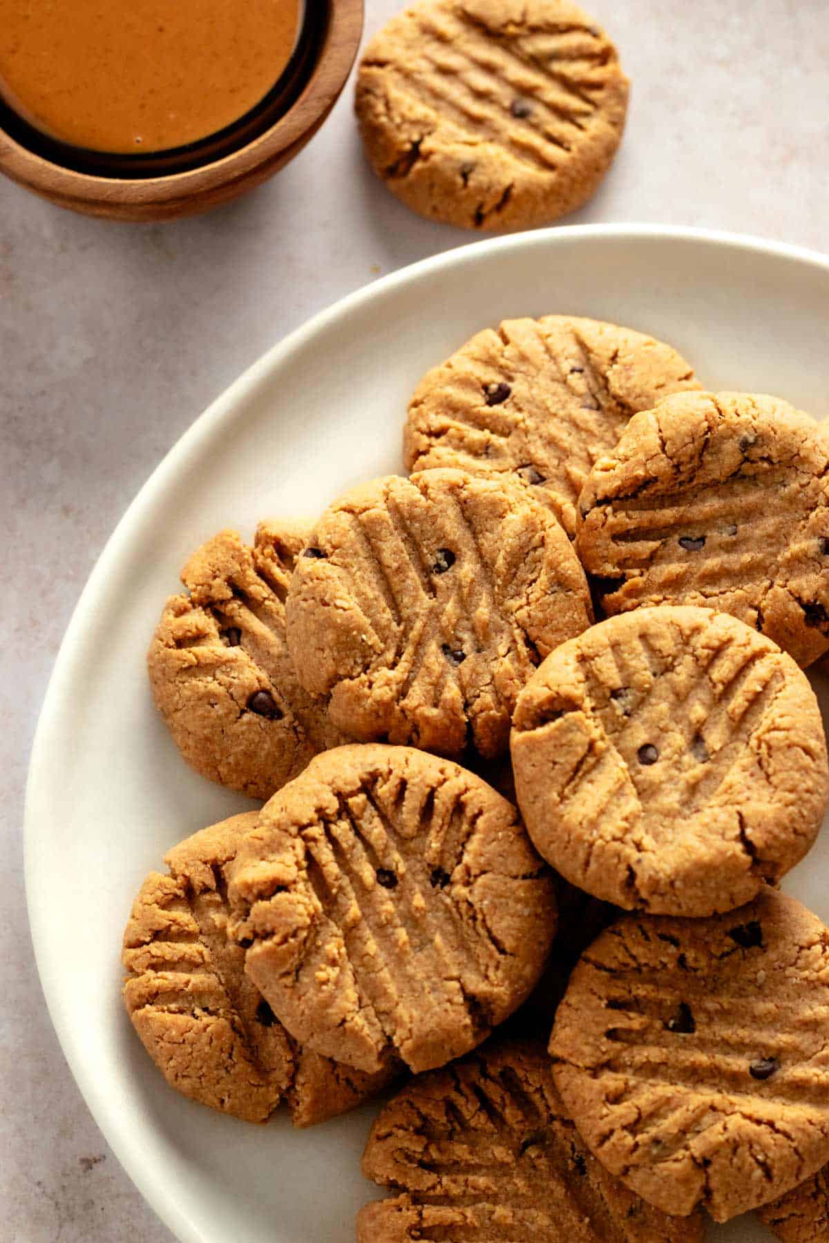 a bunch of peanut butter cookies with chocolate chips on a plate.