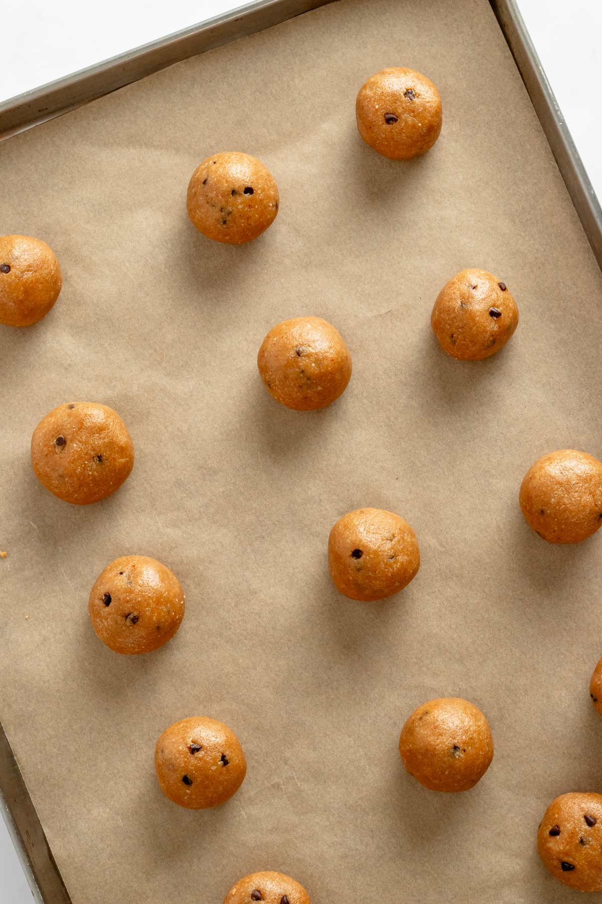 gluten free peanut butter cookie dough balls on a baking sheet.