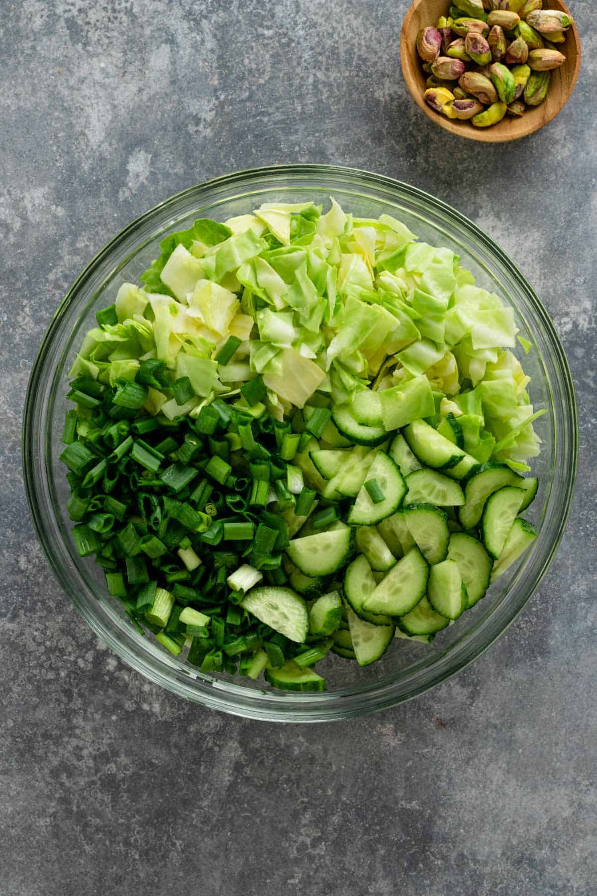 cucumbers, green onions, cabbage in a mixing bowl
