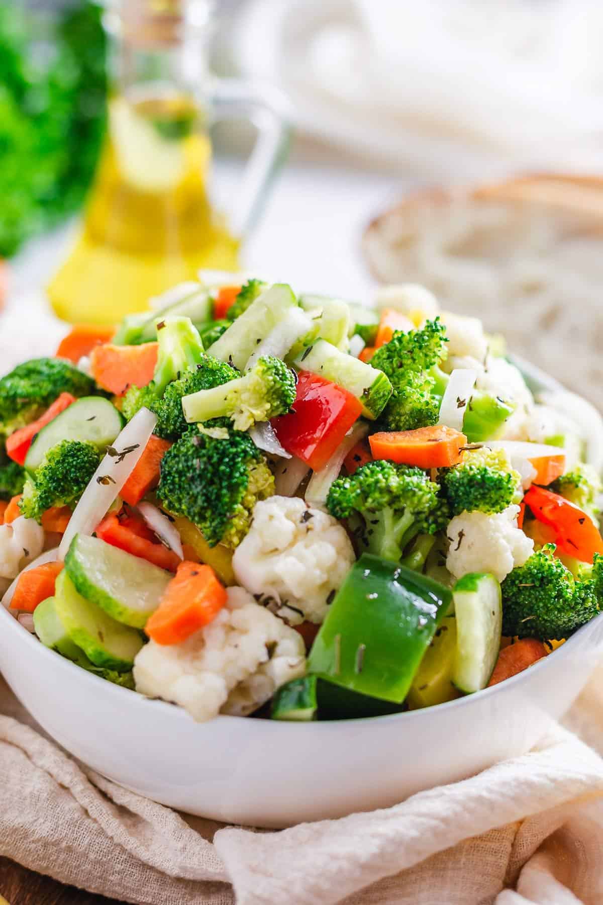 side angle shot of marinated vegetable salad in a white bowl