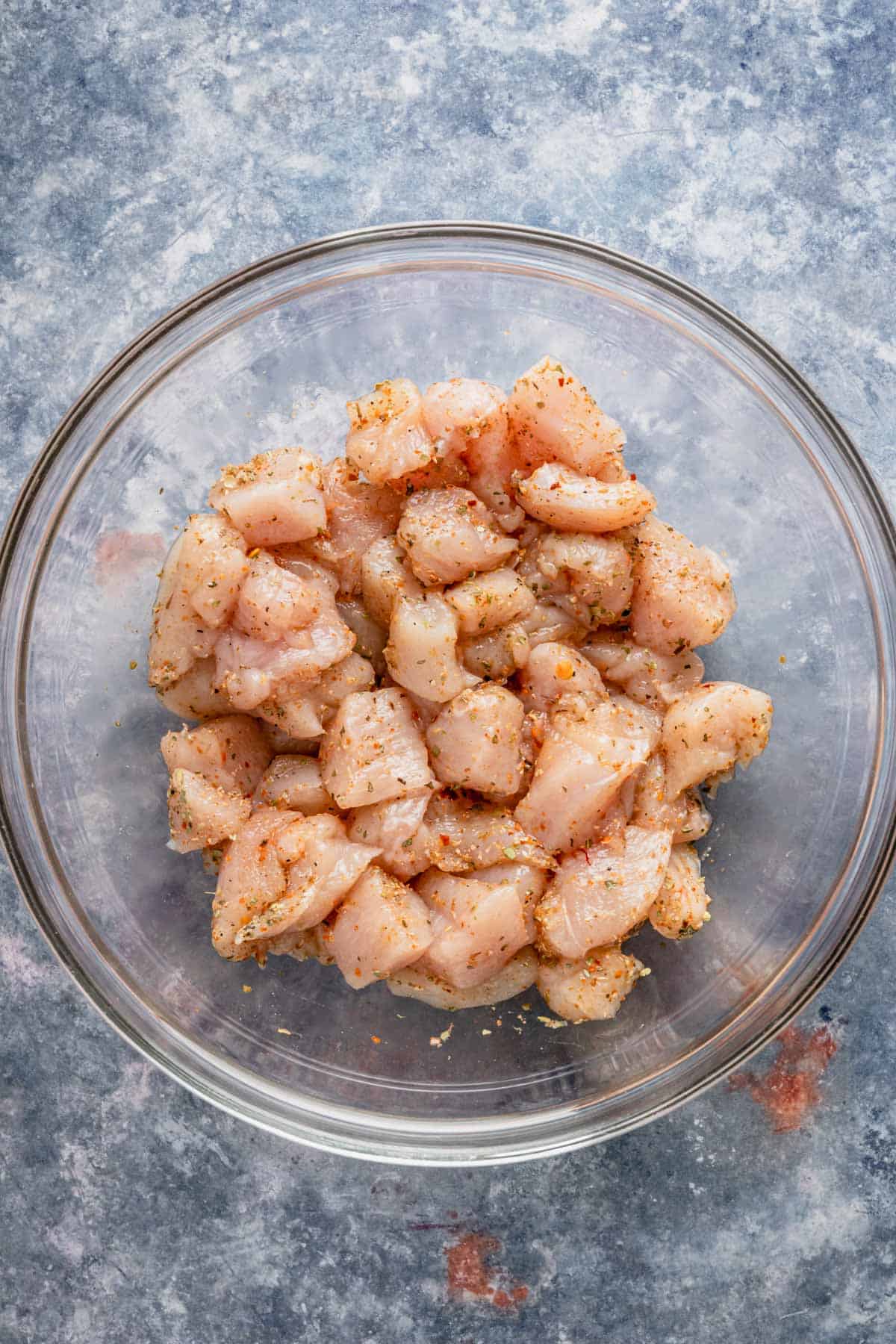 chicken pieces in bowl with spices