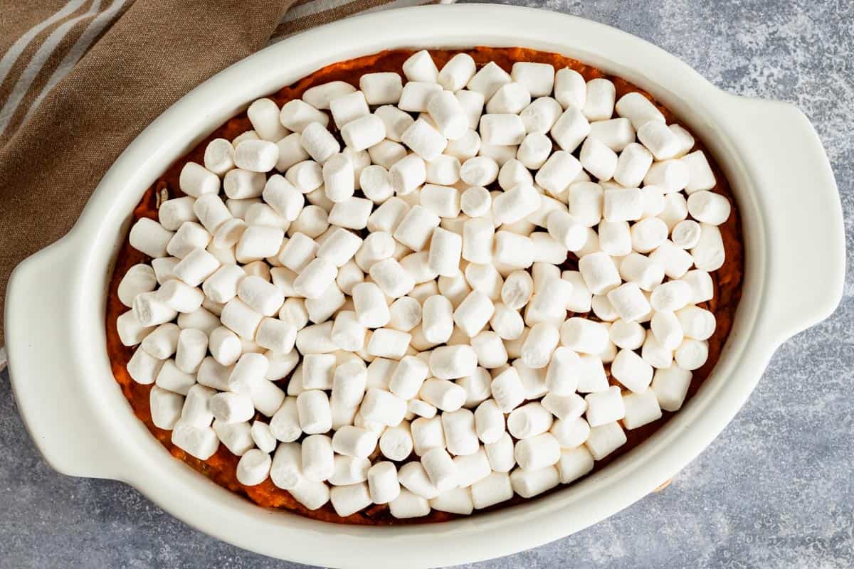 raw marshmallow topping on top of sweet potatoes.