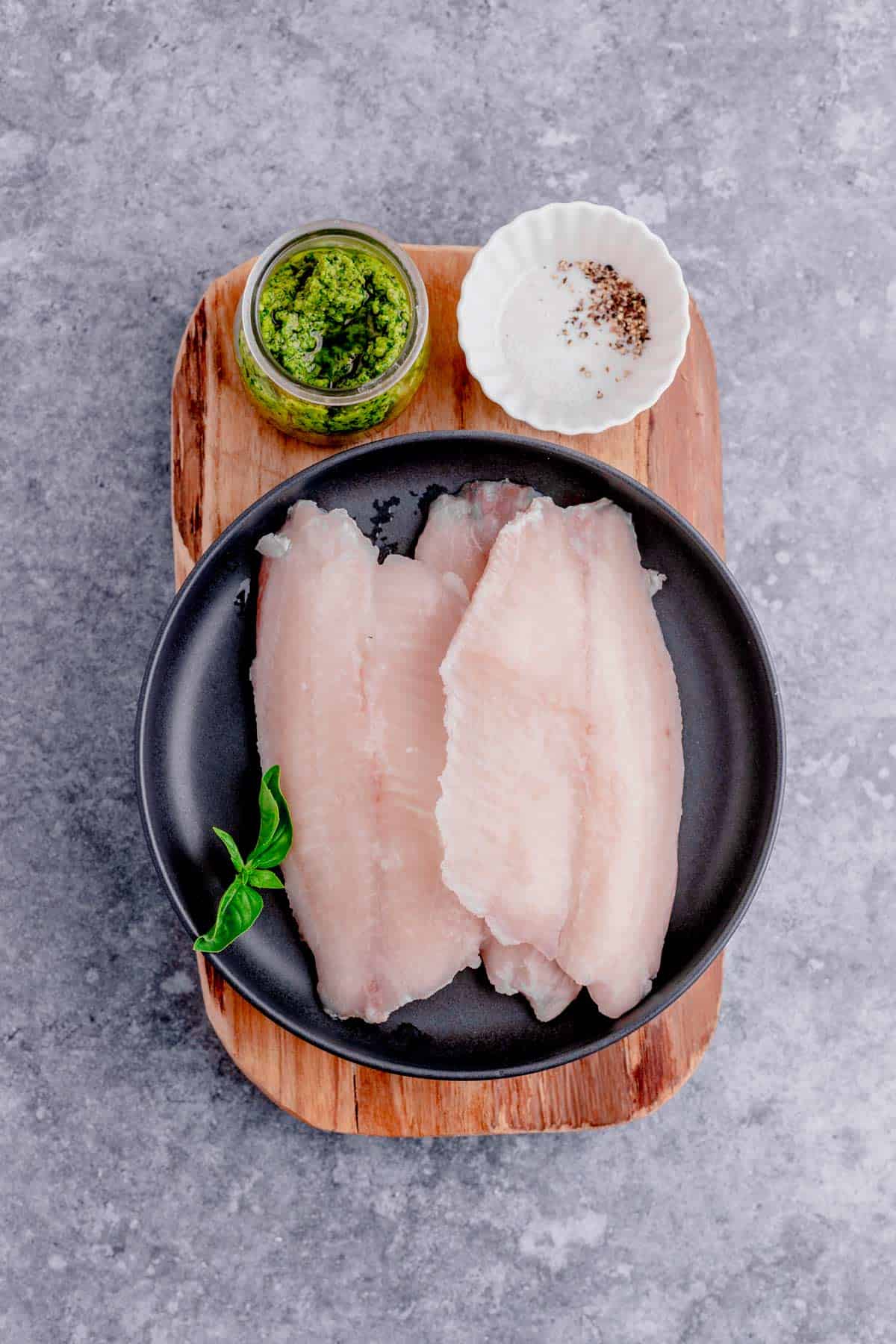 thawed tilapia fillets with pesto and seasonings before air frying