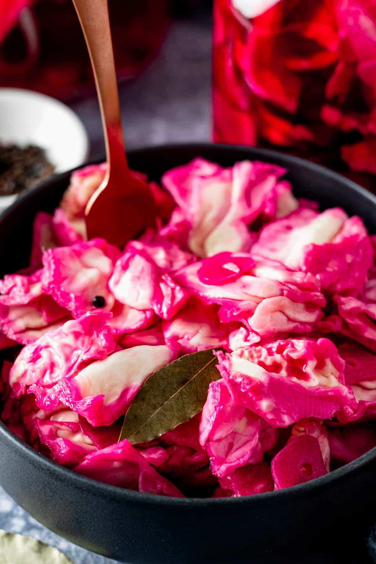 crunchy pickled cabbage with beets in a black bowl.