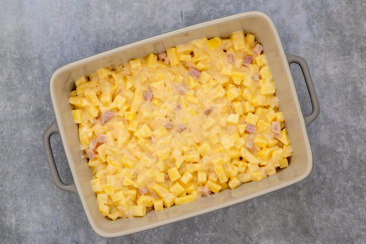 ham and potatoes with creamy sauce in casserole dish before baking