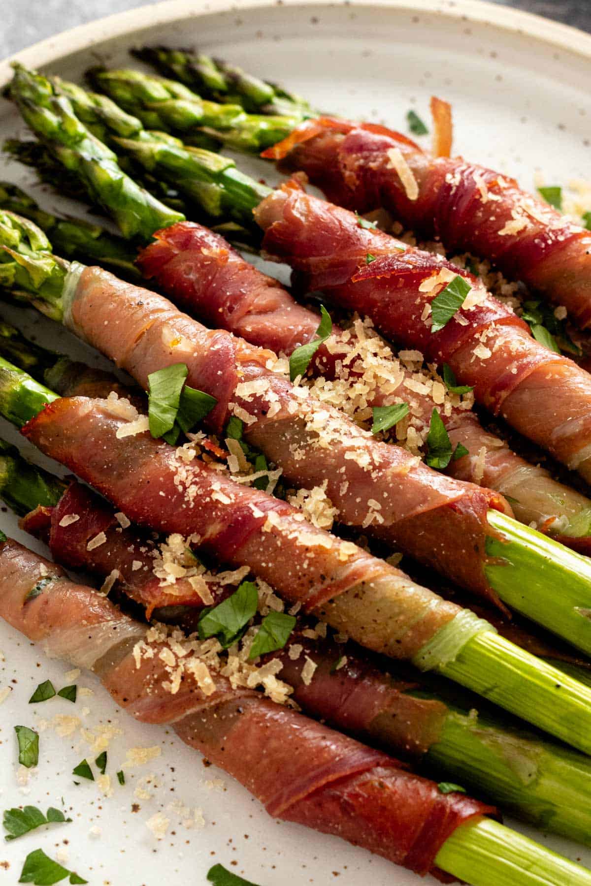 a plate of crispy prosciutto wrapped asparagus in oven.