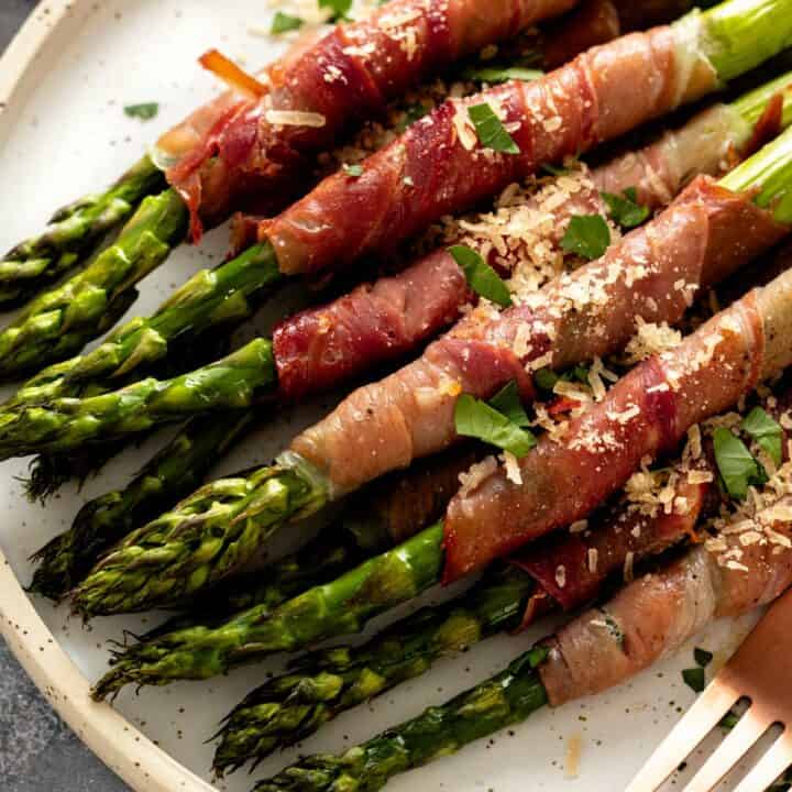 a plate of crispy prosciutto wrapped asparagus in oven.