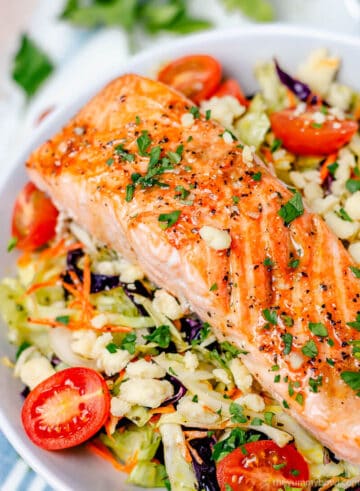 salmon salad bowl in a white bowl with parsley and cabbage