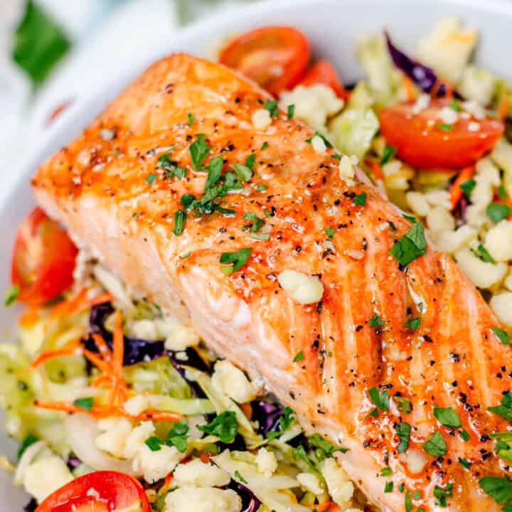 salmon salad bowl in a white bowl with parsley and cabbage