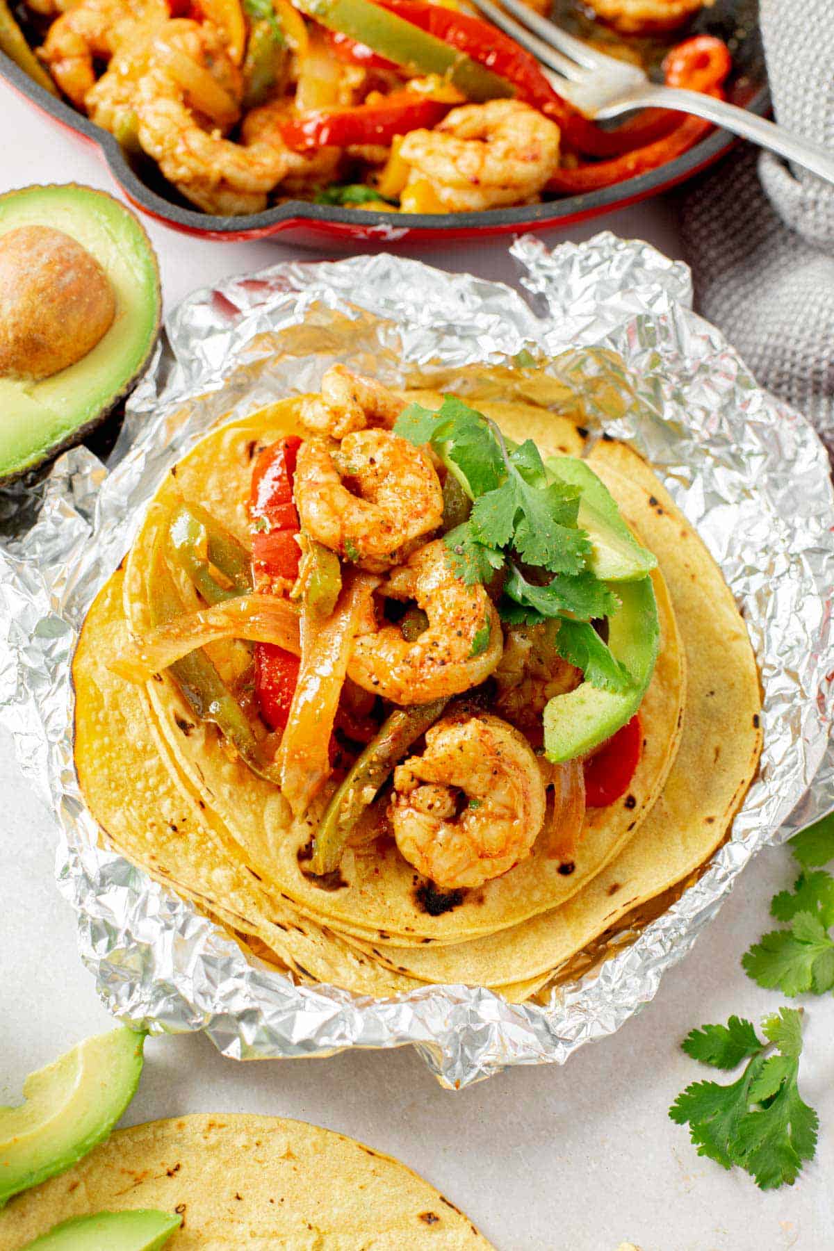 shrimp fajita with vegetables served in a corn tortilla ona foil