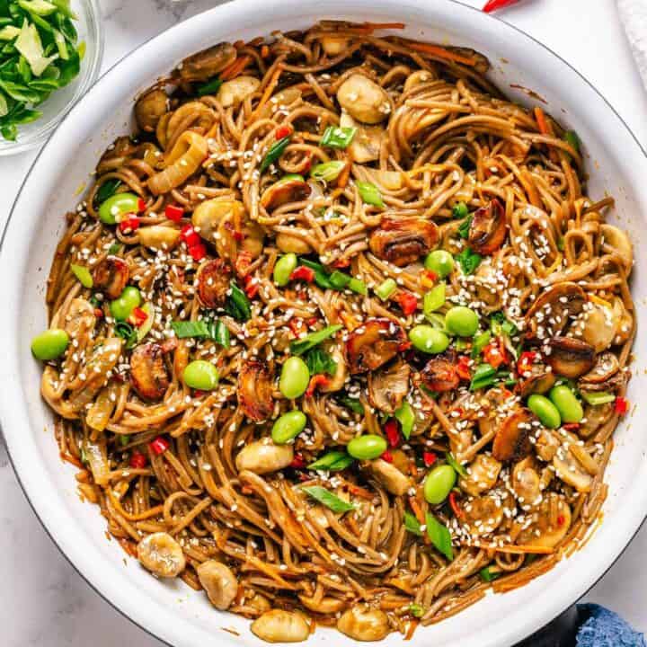 Soba Noodles Stir Fry in a white skillet with garnishes