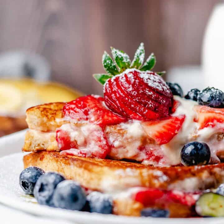 stuffed cream cheese french toast sandwich stack closeup bite shot ona plate with wooden background