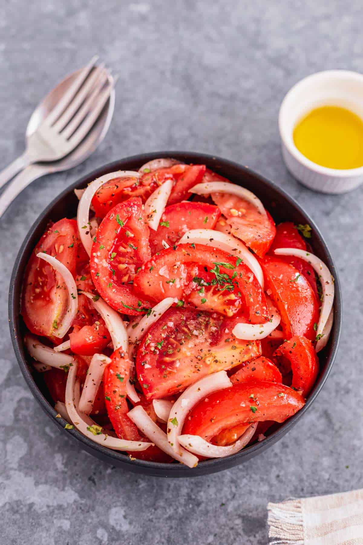 Tomato and Onion Salad with herbs in a black bowl