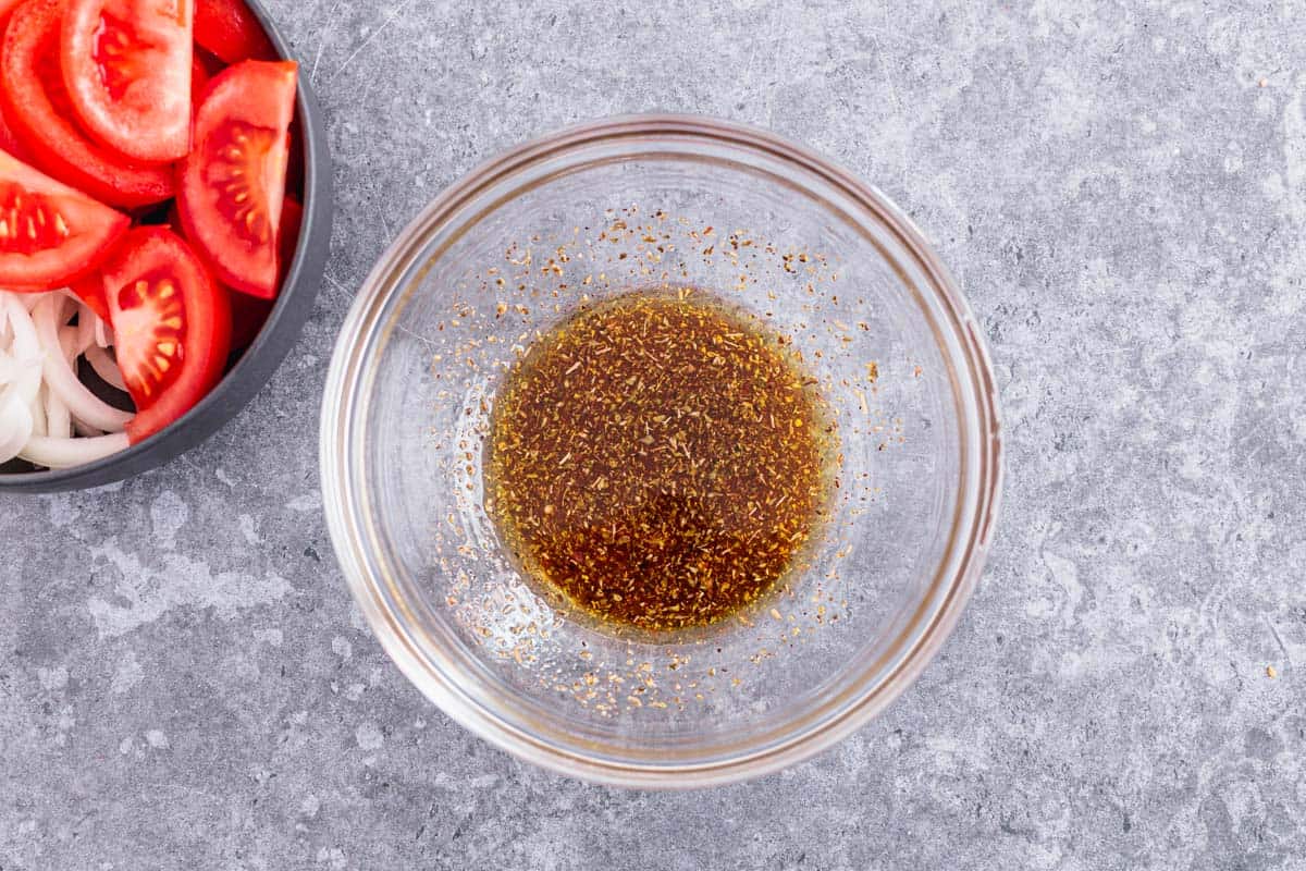 Tomato and Onion Salad with herbs in a black bowl