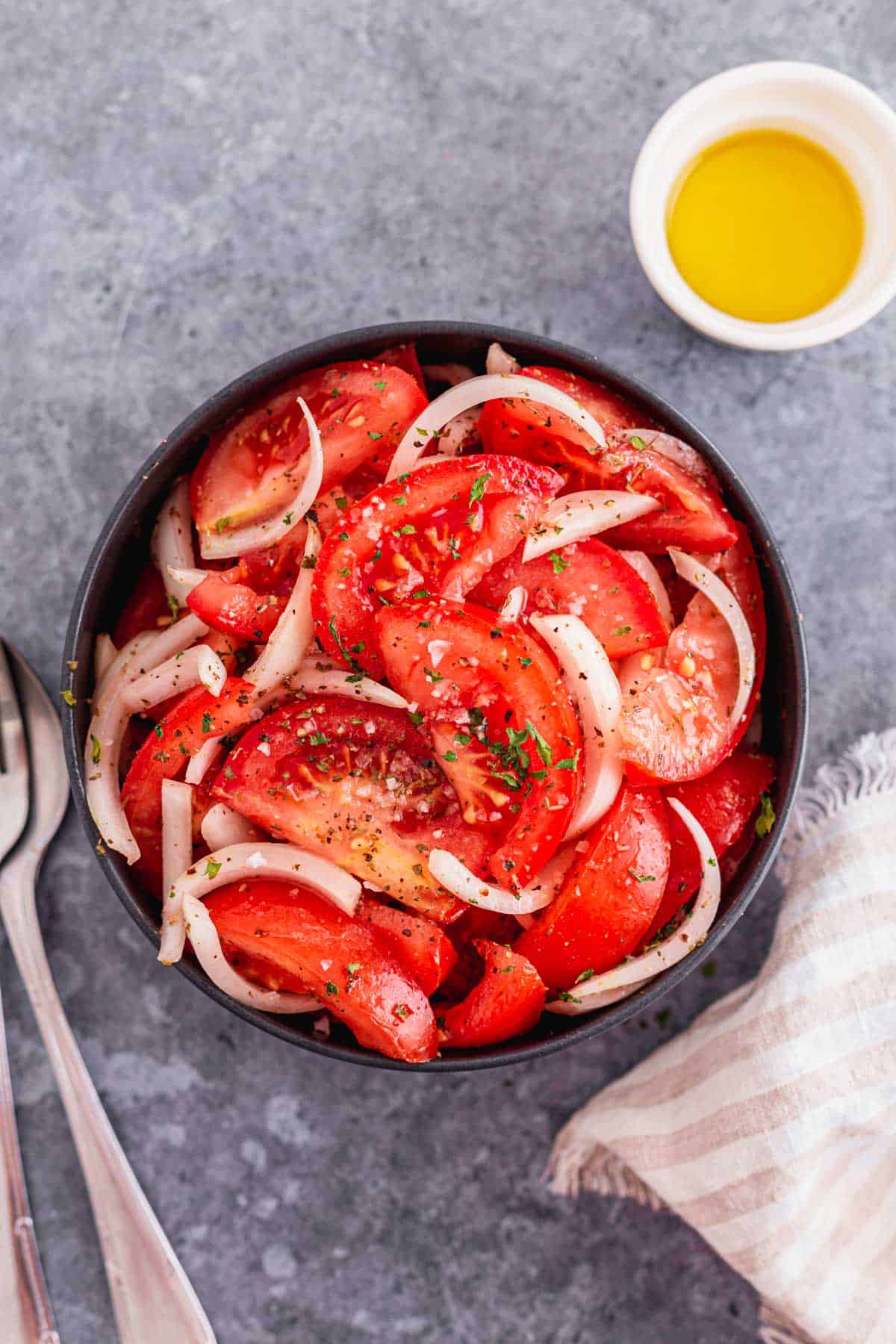 Tomato and Onion Salad with herbs in a black bowl