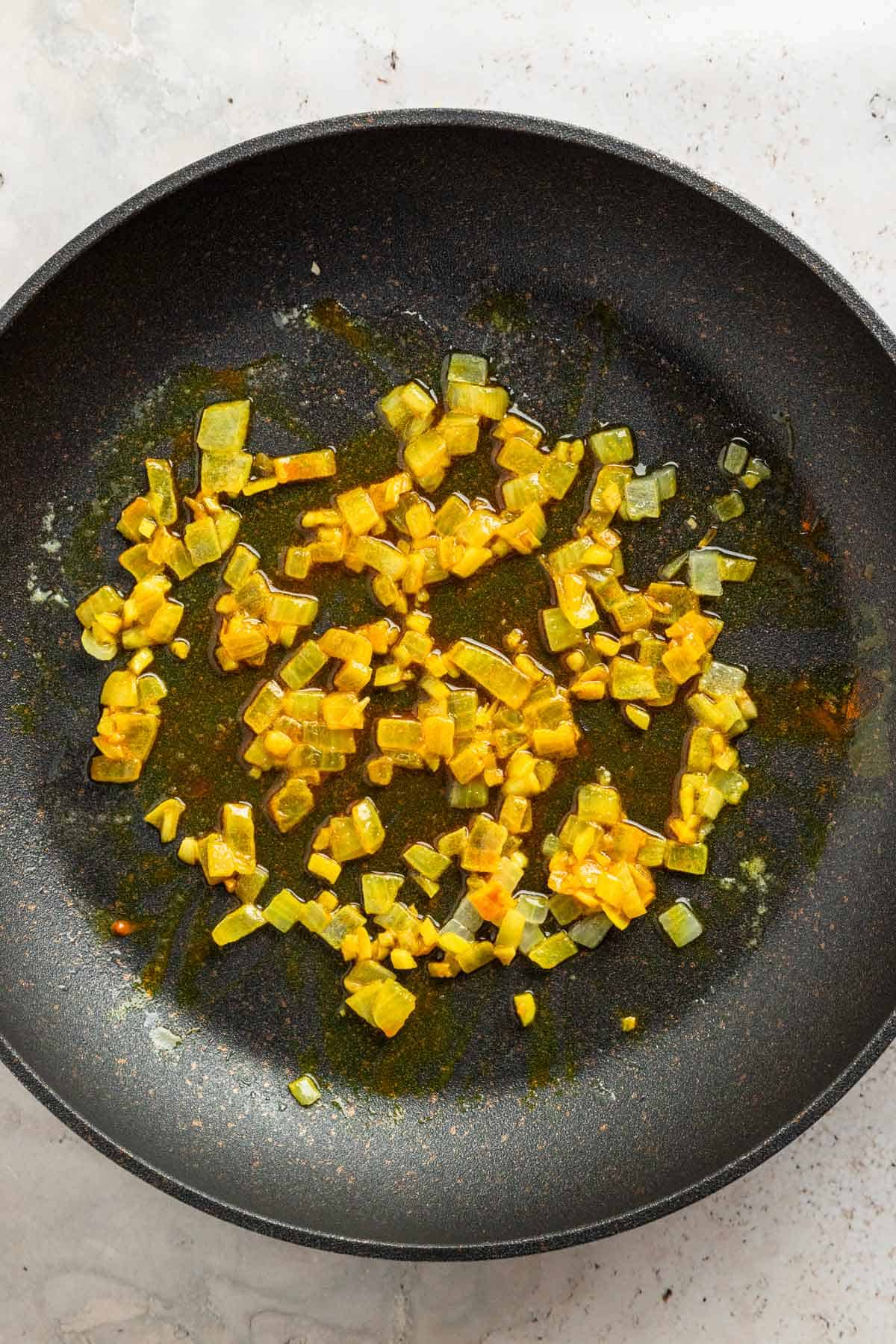 sauteing onion with turmeric in skillet.