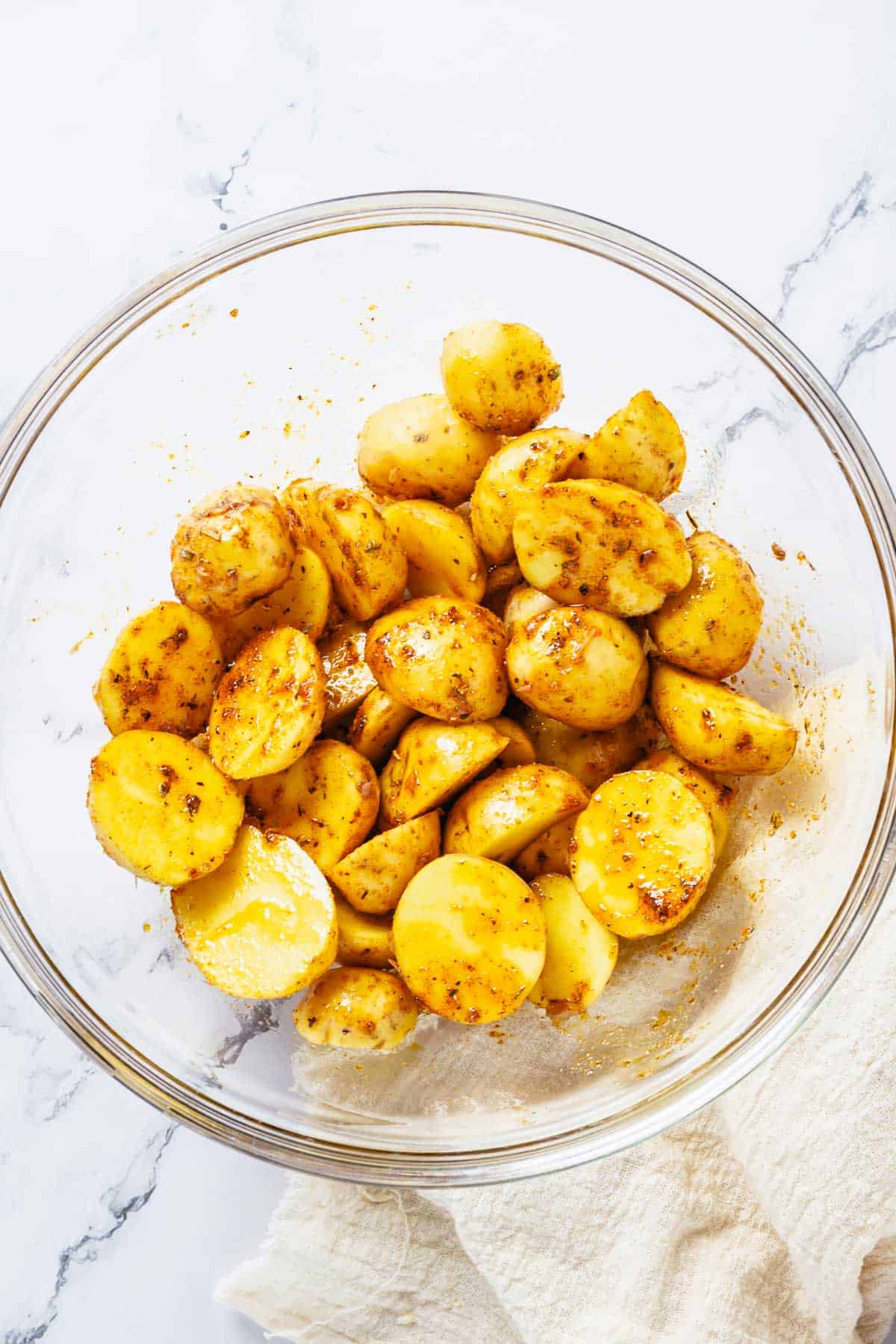 baby potatoes drizzled with marinade before baking