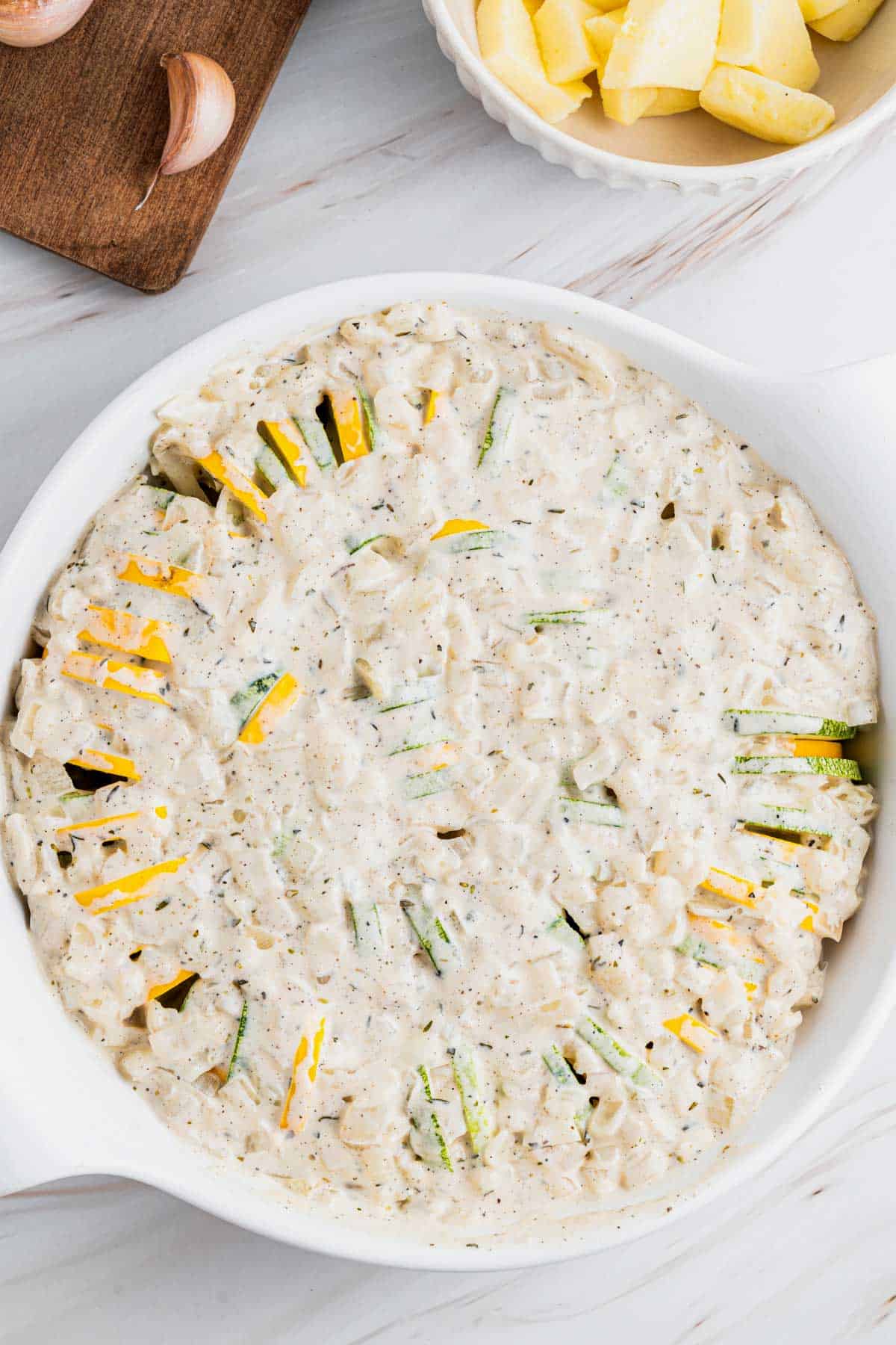 zucchini bake topped with white sauce.
